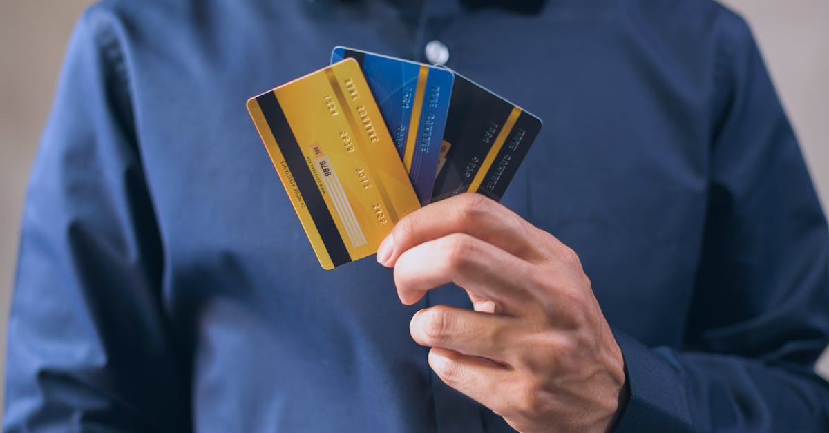 Person holding three credit cards, symbolizing finance, security, and e-commerce.